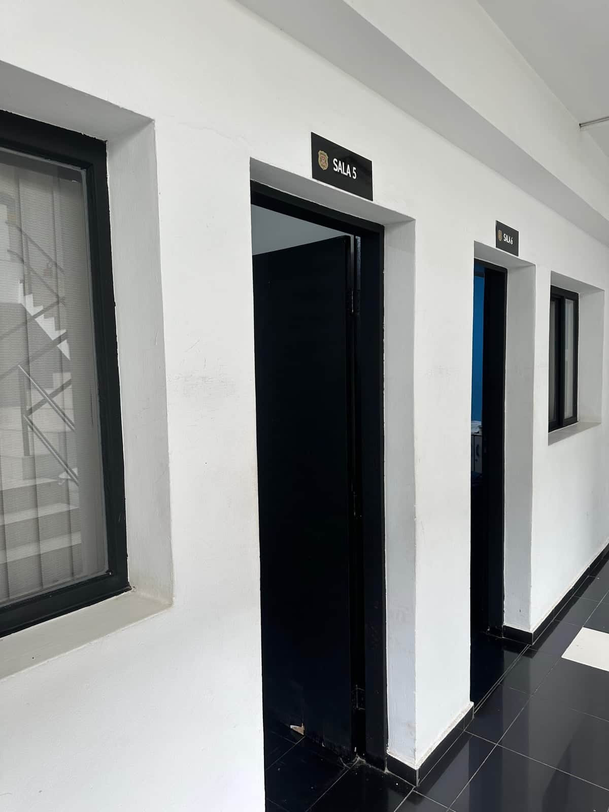 Corredor de delegacia, com portas das salas de atendimento